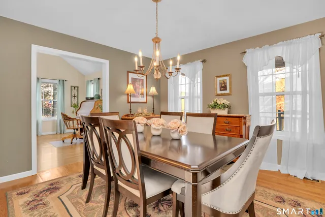 a dining room with furniture a chandelier and wooden floor