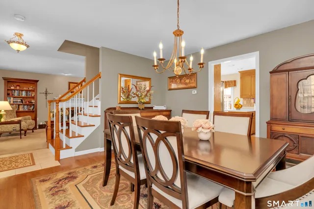 a view of a dining room and livingroom with furniture wooden floor a chandelier
