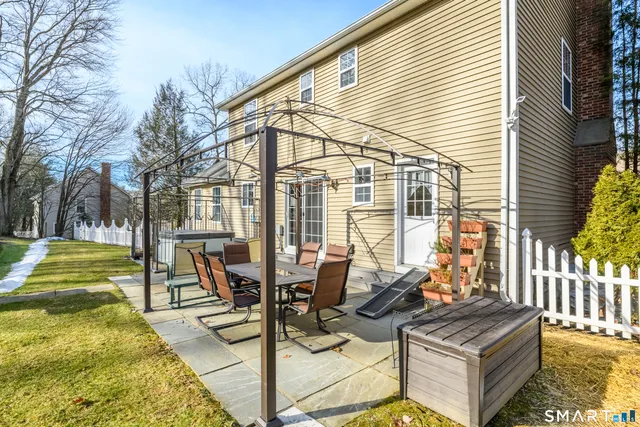 a view of a patio with table and chairs and wooden fence