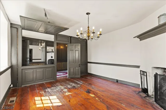 a view of a hallway with wooden floor and chandelier