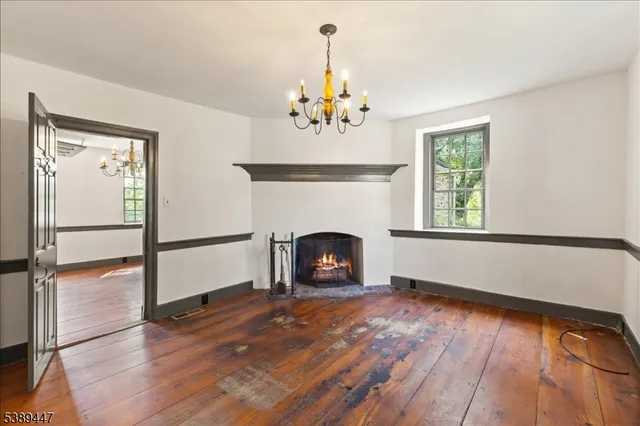 a view of an empty room with a window and fireplace
