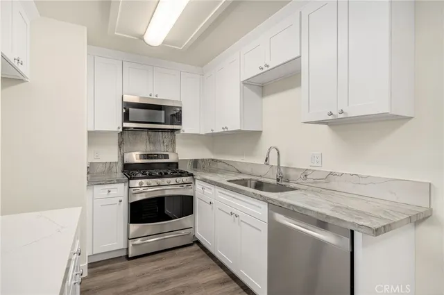 a kitchen with stainless steel appliances granite countertop a sink stove and cabinets