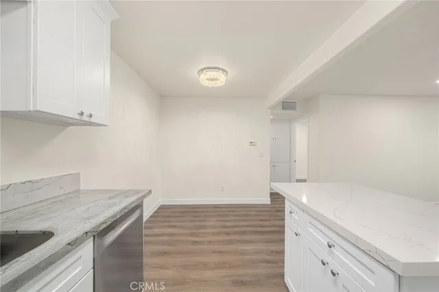 a kitchen with a sink cabinets and wooden floor