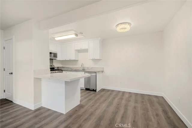 a kitchen with a sink cabinets and wooden floor