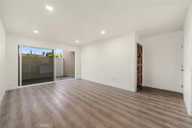 an empty room with wooden floor and entrance