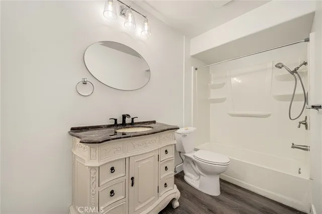 a bathroom with a granite countertop sink toilet a mirror and shower