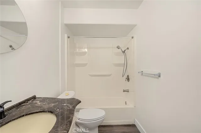 a bathroom with a granite countertop toilet a sink and shower