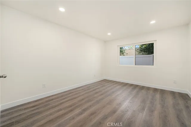 an empty room with wooden floor and window