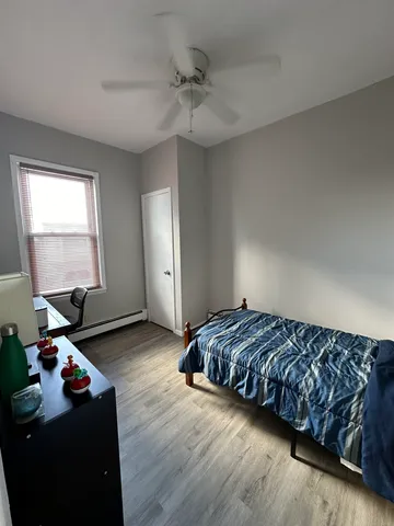 a bedroom with a bed and wooden floor