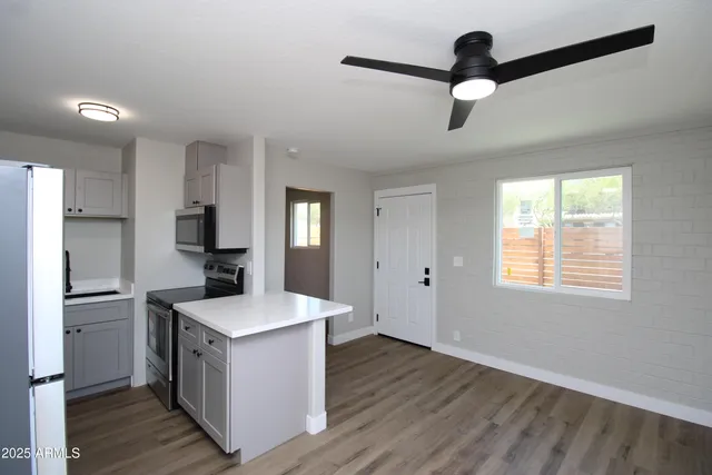 a kitchen with a refrigerator and ceiling fan