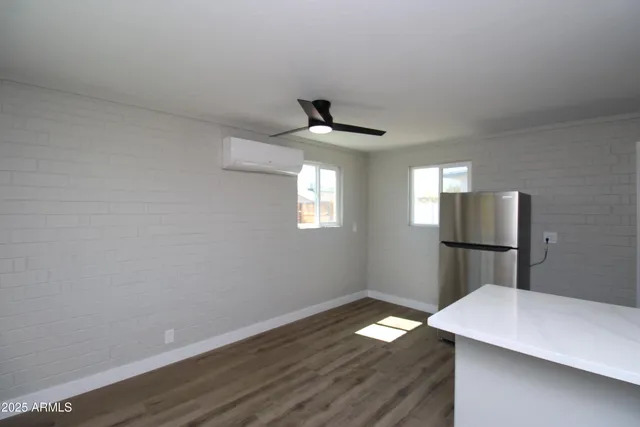 a room with wooden floor and ceiling fan
