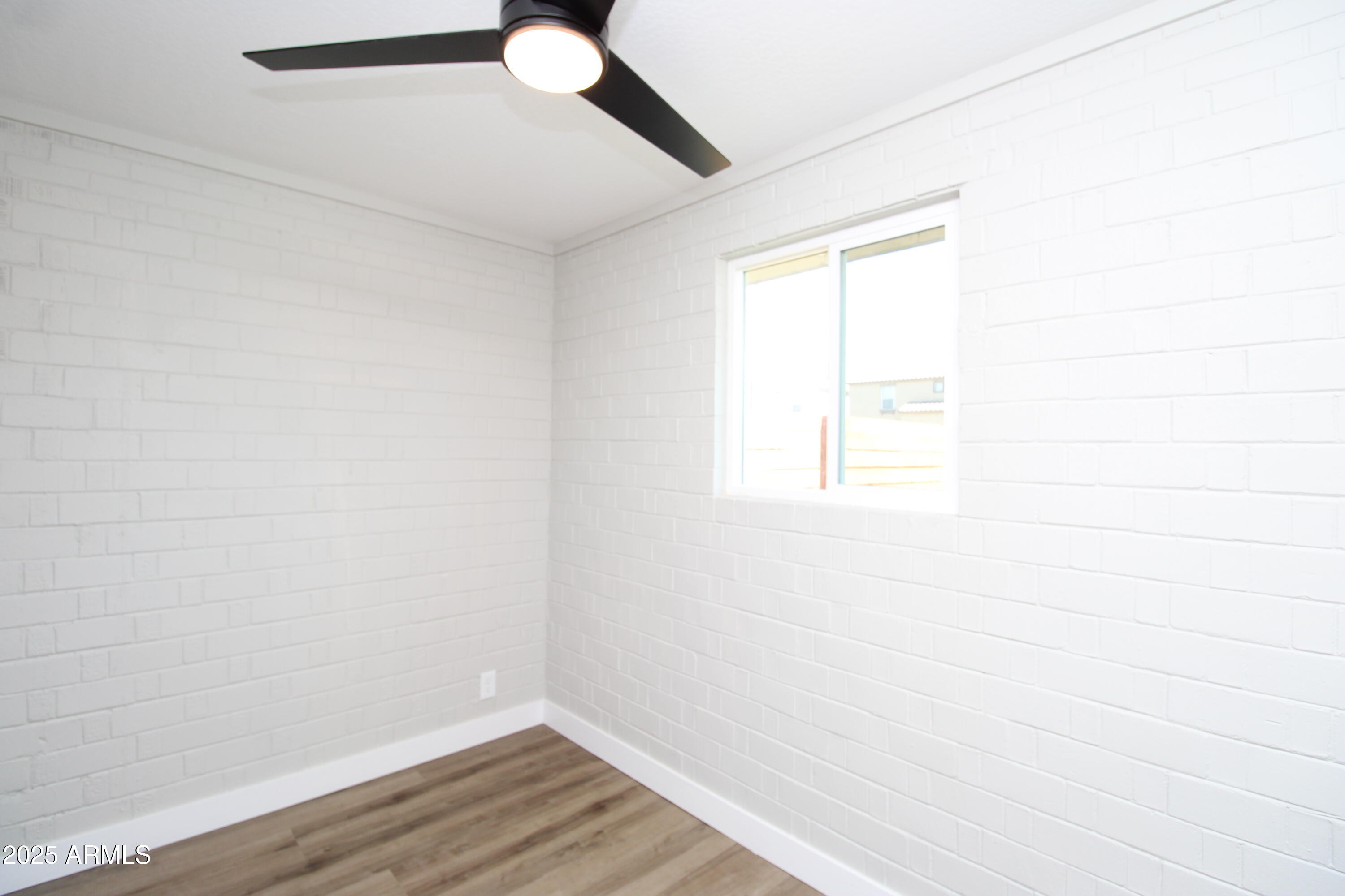 802 South 11th Avenue, Unit 4 Phoenix, AZ 85007 - Photo 7 of 11 a view of an empty room with wooden floor and a window