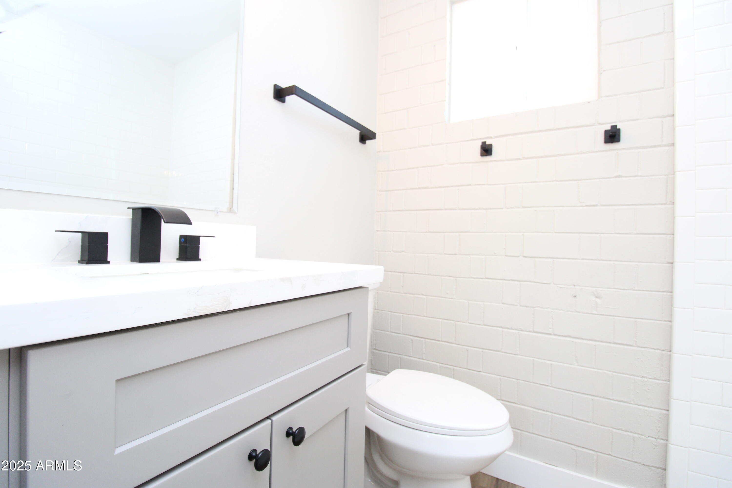 802 South 11th Avenue, Unit 4 Phoenix, AZ 85007 - Photo 9 of 11 a bathroom with a toilet a sink and mirror