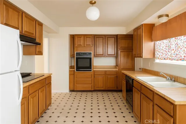 a kitchen with a sink a stove cabinets and a window