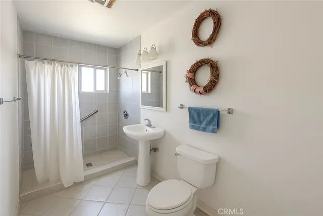 a bathroom with a toilet sink vanity and mirror