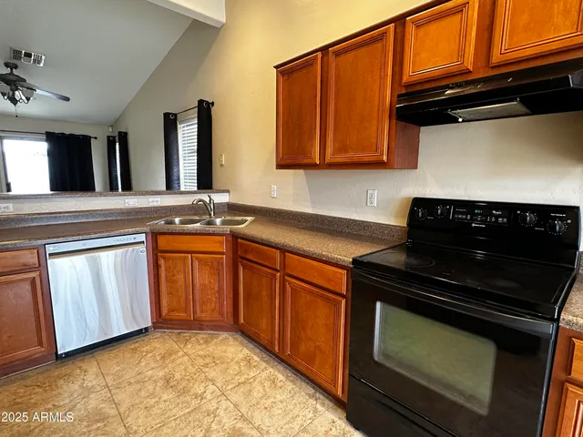 a kitchen with granite countertop a stove sink and cabinets