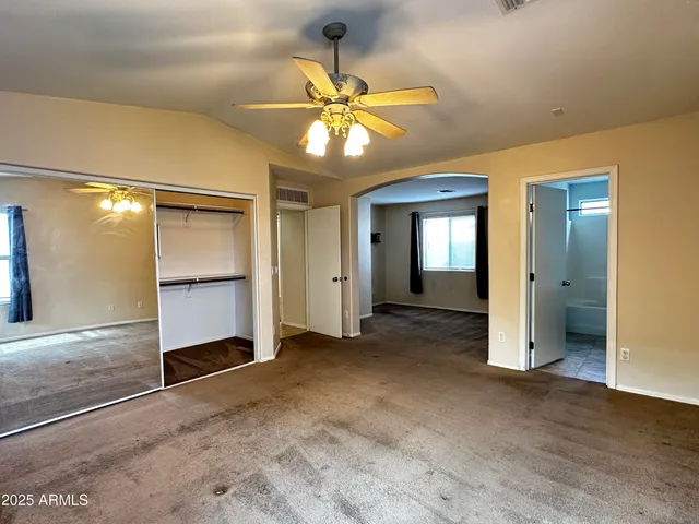 an empty room with closet and windows