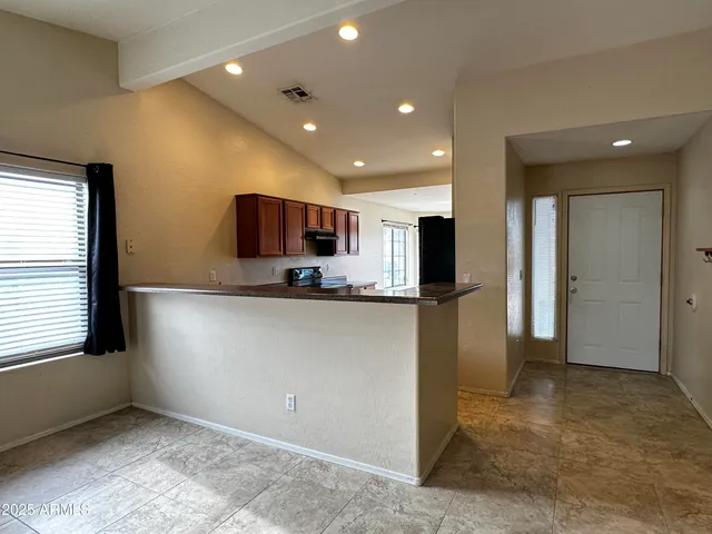 a view of kitchen with refrigerator and window
