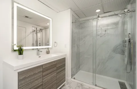 a bathroom with a double vanity sink mirror and shower