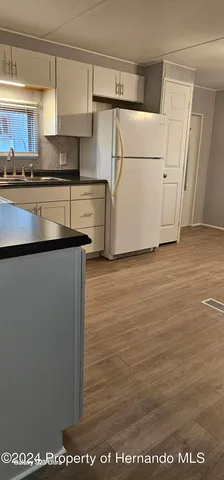 a kitchen with stainless steel appliances granite countertop a stove a sink and white cabinets