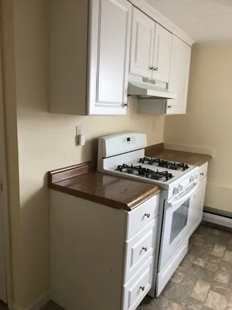 a kitchen with granite countertop white cabinets and white appliances