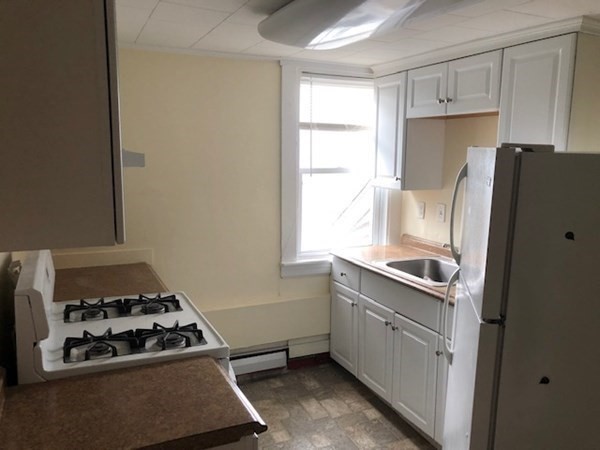 93 Main Street, Unit 3 North Andover, MA 01845 - Photo 8 of 11 a kitchen with a stove a refrigerator and a window