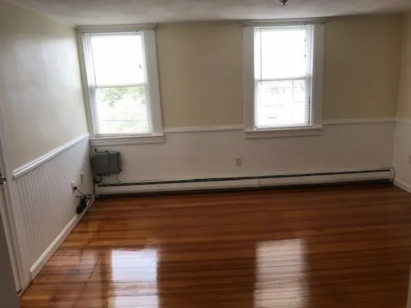 a view of a room with wooden floor and a window