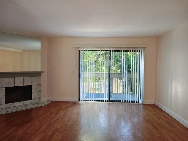 wooden floor fireplace and natural light in room