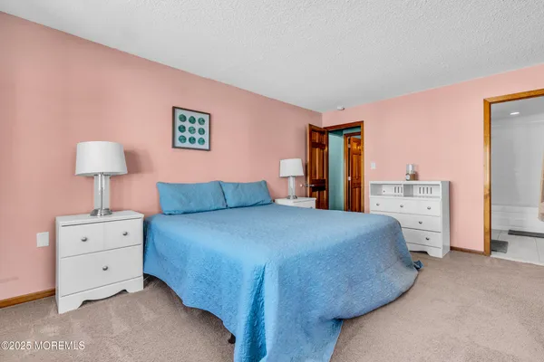 a spacious bedroom with a bed and a lamp