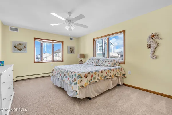 a bedroom with a bed painting on wall and a window