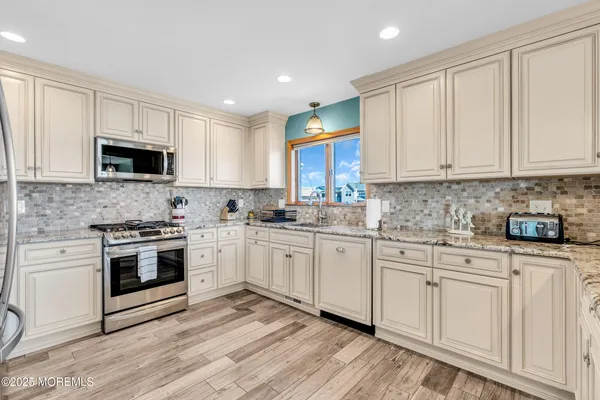 a kitchen with granite countertop white cabinets and appliances