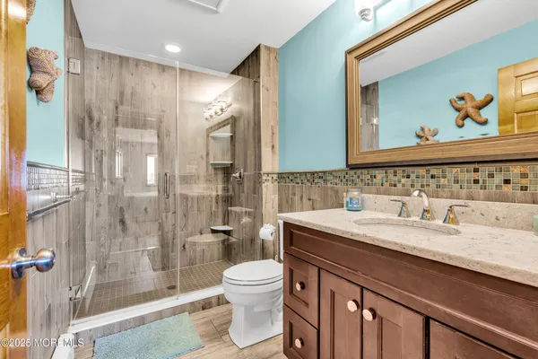 a bathroom with a double vanity sink toilet and shower