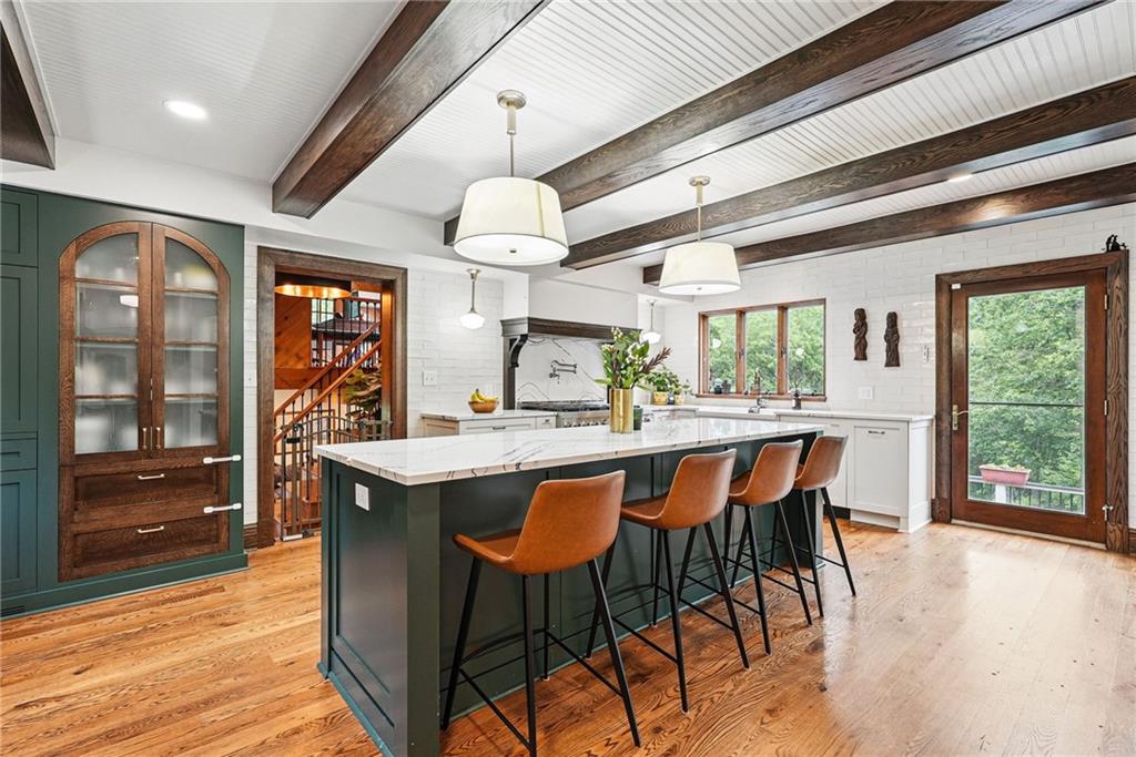 30 Club Road Carnegie, PA 15106 - Photo 23 of 49 a dining hall with stainless steel appliances granite countertop a sink dishwasher a dining table and chairs with wooden floor