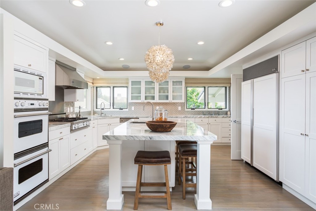 704 Emerald Bay Laguna Beach, CA 92651 - Photo 12 of 27 a kitchen with stainless steel appliances granite countertop a stove top oven a sink dishwasher and white cabinets with wooden floor