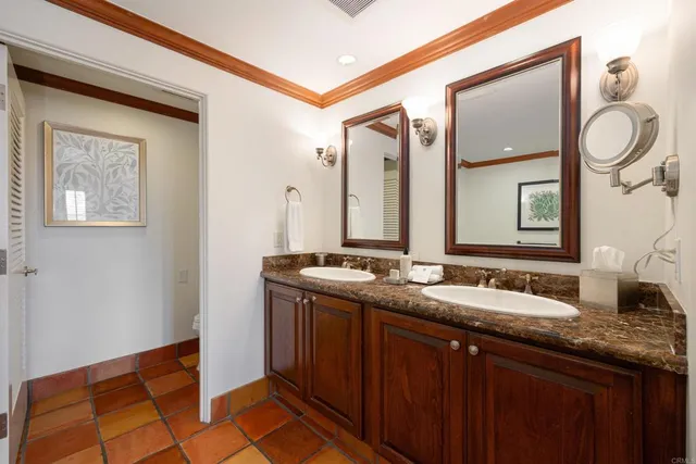 a bathroom with a granite countertop double vanity sink and a mirror