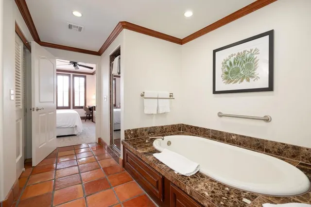 a bathroom with a tub a mirror and a shower