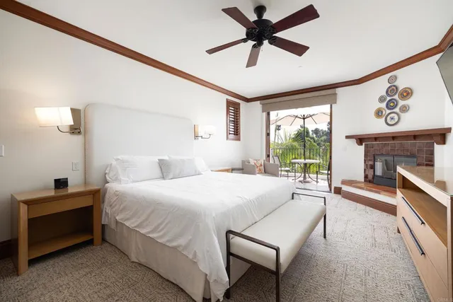 a bedroom with a bed a fireplace and a large window