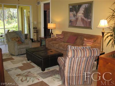 13002 Pennington Place, Unit 101 Fort Myers, FL 33913 - Photo 3 of 10 a living room with furniture and a painting on the wall