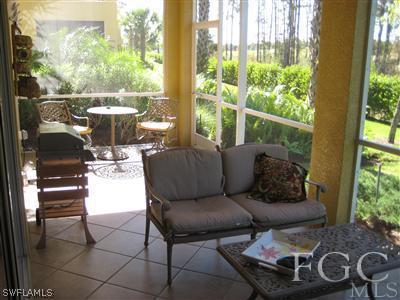 13002 Pennington Place, Unit 101 Fort Myers, FL 33913 - Photo 4 of 10 a living room with furniture and a floor to ceiling window