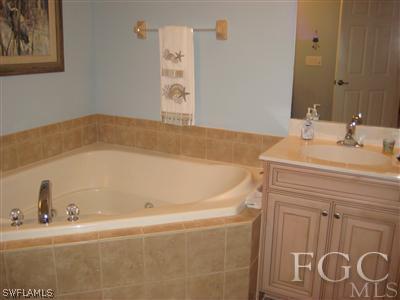 13002 Pennington Place, Unit 101 Fort Myers, FL 33913 - Photo 8 of 10 a bathroom with a bathtub and a sink