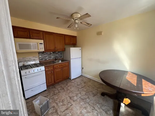 a kitchen with a stove a refrigerator and cabinets