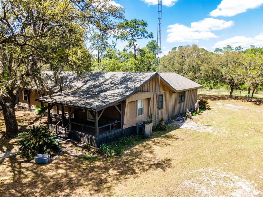 13455 Northeast 228 Ln Road Fort McCoy, FL 32134 - Photo 2 of 51 a wooden house with a large tree in front of it