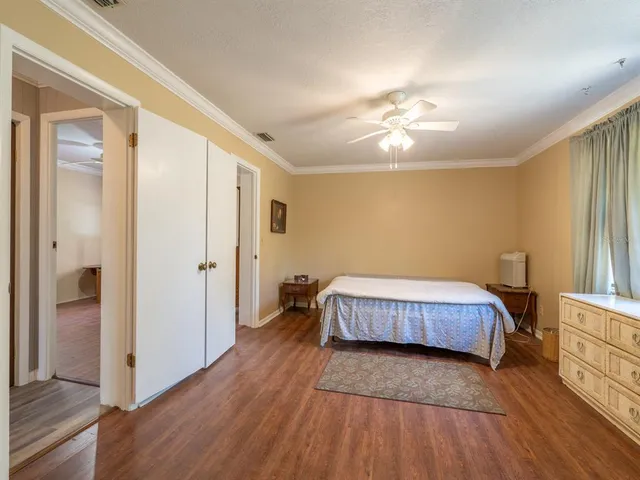a spacious bedroom with a bed and wooden floor
