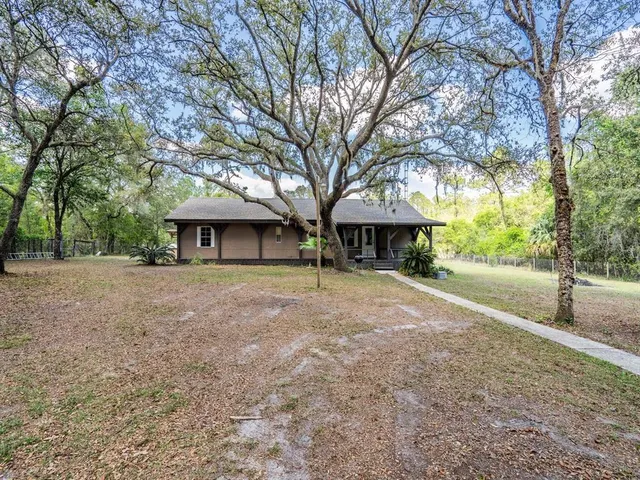 a view of a house with a tree and a yard