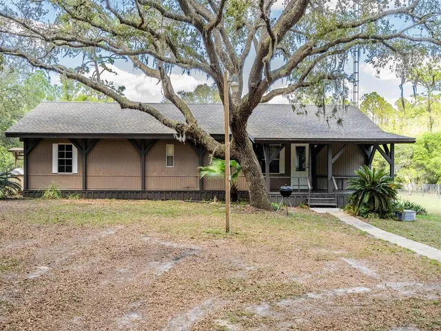 a backyard of a house with seating space and tree