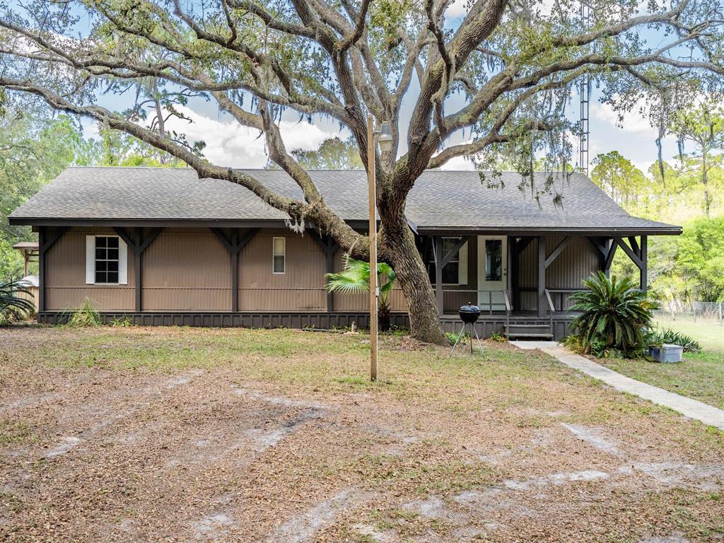 13455 Northeast 228 Ln Road Fort McCoy, FL 32134 - Photo 4 of 51 a backyard of a house with seating space and tree