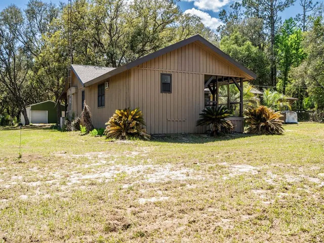 a view of a house with backyard and sitting area