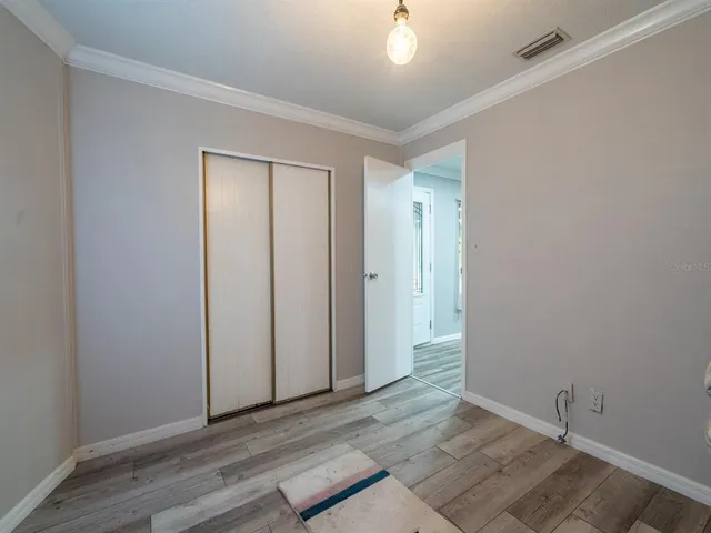 an empty room with wooden floor and closet