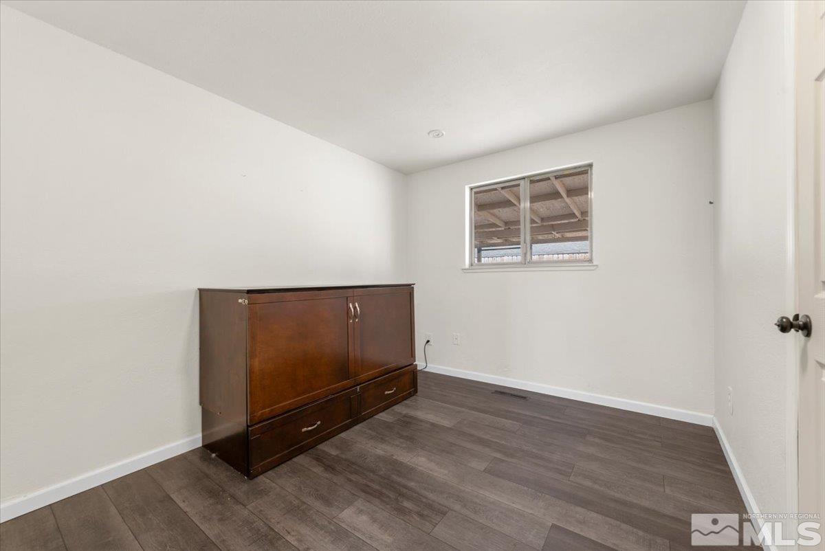 350 Sycamore Street Fernley, NV 89408 - Photo 16 of 24 a view of an empty room with wooden floor and window