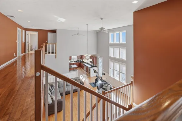 a view of a hallway with wooden floor and staircase